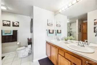 This spa-like primary bathroom features a double sink, shower, separate soaking tub, and ample storage.