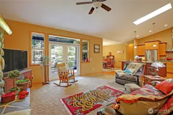 Open concept Great room, kitchen and dining room are Flooded with natural light from skylight in the vaulted ceiling and French doors from both Living and dining areas that open onto outdoor living and dining on the composite planked deck. Perfect for entertaining friends and family and taking in glowing sunsets.