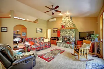 Great room features vaulted ceiling, river rock gas fireplace, skylight, arched entry to home office, French doors to spacious deck. Mini-split and ceiling fan keep you cool in summer and warm in winter.