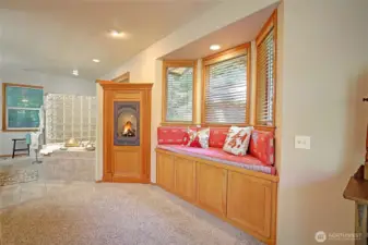 Primary suite bowed window niche with cozy window seating and built-in cabinetry. Enjoy a toasty fire and the glow and ambiance as the weather cools. High end finishes include wood-wrapped windows and doors, custom window blinds, recessed LED lighting.