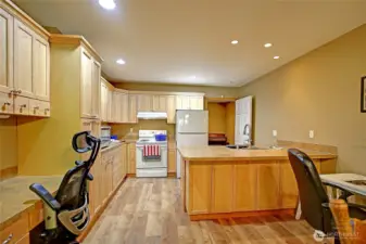 Apartment’s interior entrance into kitchen. Office space with built-in desk. Peninsula breakfast bar and additional prep and dining space. Great cutting table for quilter or hobbyist.