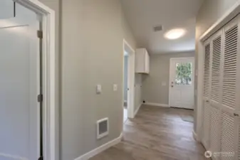 Plenty of room in this laundry located centrally to the bedrooms, bathroom and back door with handicap ramp. The doorways go to the primary suite and bedroom #2.