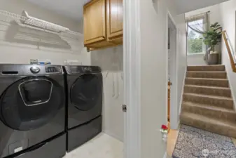 Stay organized in the laundry room with a combination of open shelves, a hanging rack, and closet cabinet storage—washer and dryer included.