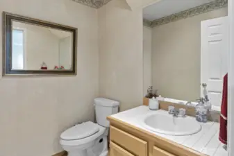 Conveniently located next to the laundry and staircase, the powder room offers easy access for guests and family.