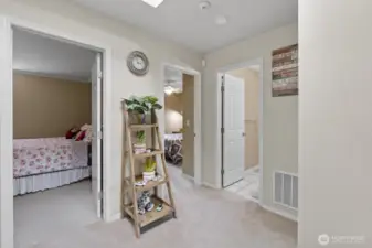 At the top of the stairs, the primary suite is straight to the left, with the shared bathroom and another bedroom on the right, creating a practical and easy-to-navigate layout.