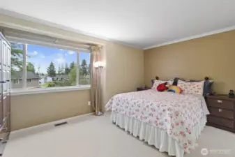 Step into the primary  suite, where stylish crown molding meets a bright box bay window, offering peaceful views of the backyard gardens.