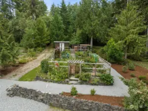 This is the upper acreage, including the fabulous garden with deer fencing. The pathway winds into the back acreage. The outbuildings include a nice potting shed, the well house and a lean to. The property is fully fenced down to the area just below the home's lower yard.