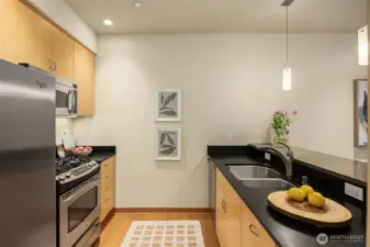 Sleek maple cabinetry is complemented by sustainable Paperstone counters and stainless appliances. The bar is an elegant quartz for subtle contrast.