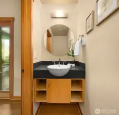 The classy powder room is directly adjacent to the front entry, tucked away from the main living spaces. So many thoughtful design choices make this home a pleasure for the homeowner and visitors alike.