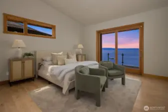 The primary suite with its vaulted ceilings and access to deck enjoys soothing water and mountain views.