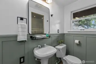Main floor bathroom with deep shower and wainscotting.