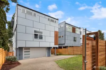 A newly installed rolling car gate provides a secure backyard with ample parking and turn-around space. The finished 2 car garage is seen straight ahead.