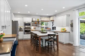 Another look towards the back of the house out to the slider. Open shelving, full height white subway backsplash. Loads of recessed can lighting for the ultimate illumination.