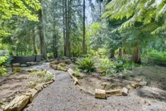 This soothing walk through the natural pathway, with many new plants to enjoy, was once all bushes, stickers and such.  Owners did a great job in making it a private oasis!