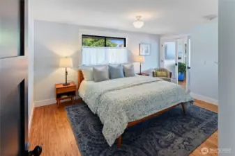 Primary bedroom has double doors to the living room, and a dressing room to the left of this photo.