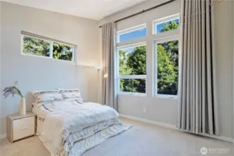 Primary bedroom with vaulted ceilings and oversized windows