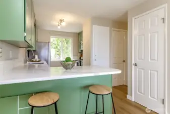 Pantry door to the right and pantry storage to the left of the half bathroom.