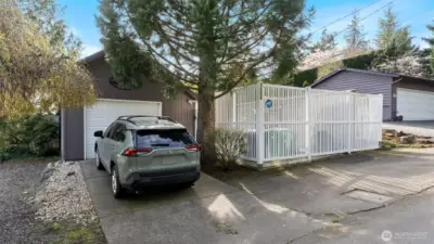 Street view with two parking spaces in addition to the garage plus a tall privacy fence