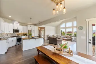 A bright & beautiful open living & dining space with expansive hickory flooring & a glass door to show the view leading to your outdoor living space