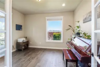 Beautiful French door entry into the roomy den with hickory flooring. The space makes a great music room or added living space