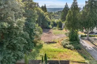 View from over the East end of the parcel looking west. Approximately 1/4 of the property has been cleared in anticipation of development. The grassy area in the foreground of the photo is an easement for the primary and reserve area of the adjacent property's septic system.