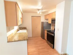 Kitchen w/slab granite counters, tile backsplash, stainless appliances.