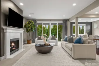 Spacious living room with gas fireplace floor to ceiling sliding doors that fill the space with light and nature.