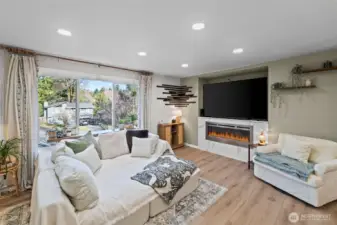 Cozy living room with large picture window and modern electric fireplace.