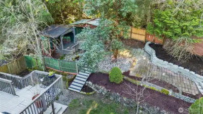 Many great spaces to retreat to in this private backyard including these charming covered outbuildings for hobbies and gatherings!