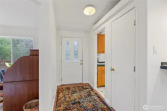 View of the front door with the kitchen to the right and den/office to the left.