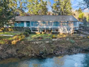 Back of home shows creek proximity.  Plastic was erected to protect deck when applying materials.  Like protection so not eager to remove