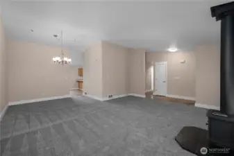 View from expansive vaulted living space towards potential dining space within living room. This space could be utilized for dining, but could alternatively serve as additional living space, flex space, etc. Living room has wired surround sound speakers and multiple cable conduits for easy entertainment hook ups!