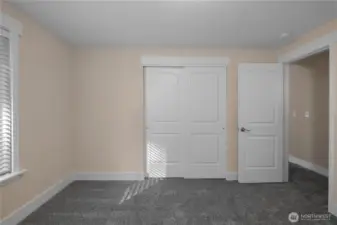 Alternate view of bedroom number one showcasing your large closet and light filled window to the left. View of hallway through doorway with bathroom across the hall. New carpeting and fresh paint!