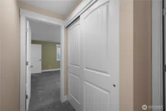 Hallway turns left to lead to your primary suite! Closet on right is fantastic sized linen closet with built in racks. New carpeting and fresh paint.