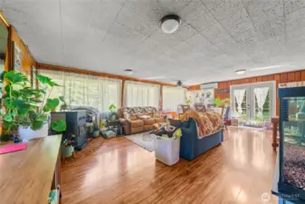 Cabin living room. Lots of natural light. Laminate floors, mini split for heating and cooling plus a pellet stove if you really need to warm up!