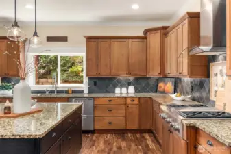 Built-in stainless-steel appliances, slab granite surfaces, & stylish tile backsplash.