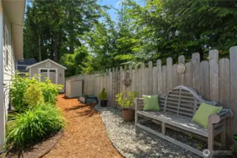 A serene place to read a book or just listen to the birds chirp. There are beautiful perennial plantings around the home. Great storage shed in background.