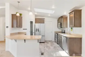 The kitchen is very functional and there is a large pantry next to the refrigerator.