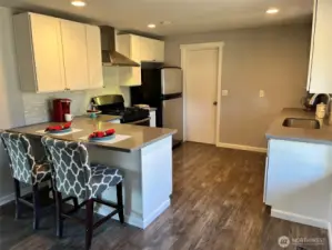 Shaker cabinets, quartz counters, stainless appliances, undermount sink, and tile backsplash.