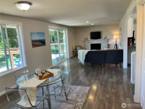 Great room with fireplace, deck access opens to dining space and eat-in kitchen.