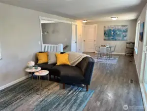 Great room with fireplace, deck access opens to dining space and eat-in kitchen.