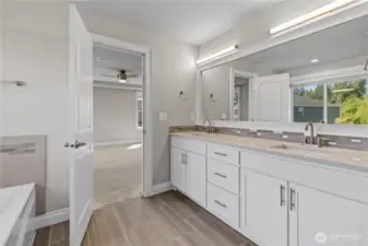 Primary Bath with Dual Quartz Vanities, Tiled Floors, Jetted Tub and Abundant Cabinet and Drawer Space.
