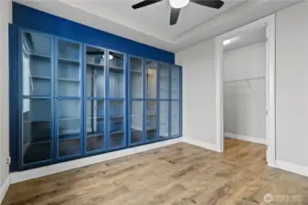 Main Level Bedroom or Office Space Features Beautiful Glass Cabinetry, Ceiling Fan and a Walk-in Closet.