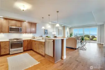 An open-concept layout is elevated by rich engineered hardwood floors and floor-to-ceiling windows that bathe the space in radiant natural light—creating a warm, refined ambiance throughout.