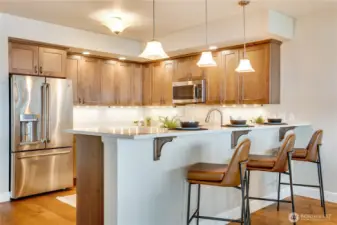 The oversized breakfast bar provides casual dining, generous prep space, and a seamless connection to the heart of the home.