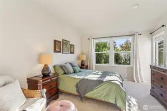 Big bedroom with privacy shrubs outside the windows.