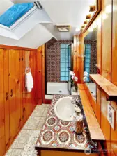 4403...Upper floor 3/4 bath with built-in storage area, tile counter, skylight and shower stall with glass block for natural light.