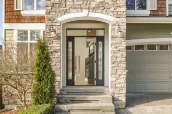 Grand Entry with rich stonework creates an impressive and inviting atmosphere.