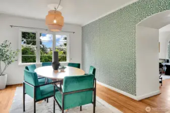 Large dining room with designer wall paper filled with light and made for entertaining.