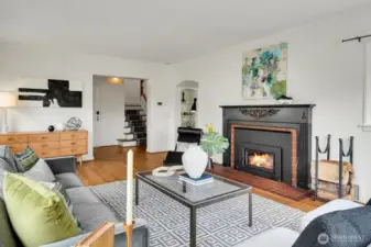 Sun-filled expansive living room with wood burning fireplace.